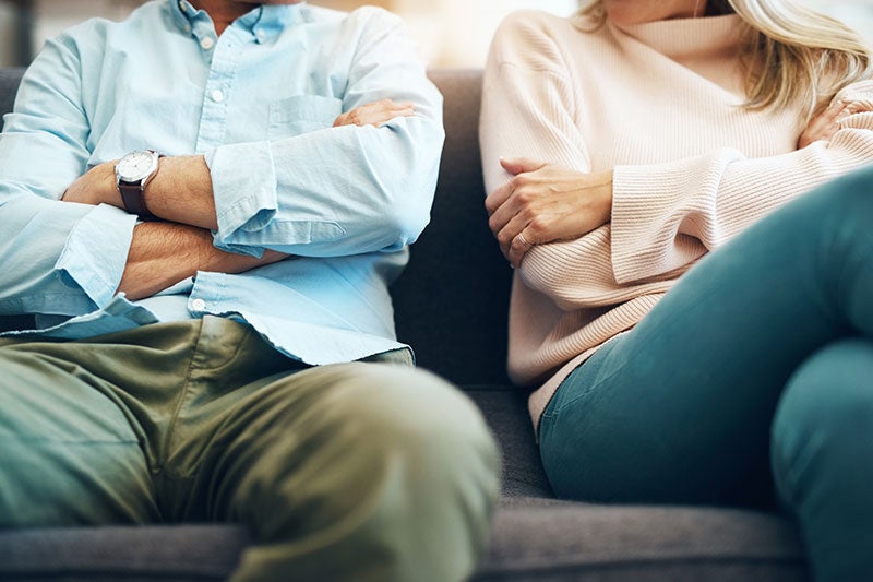 Couple sitting with arms crossed, showing marital conflict or distance.