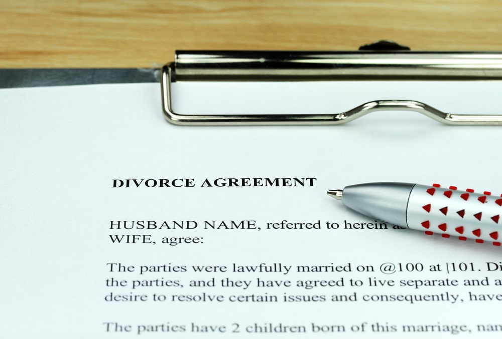 Divorce Agreement Documents And A Pen Laying On A Table