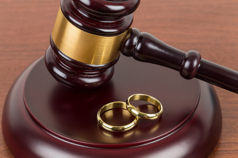 Photo of a Pair Of Gold Rings Laying On The The Table Next To A Judges Hammer