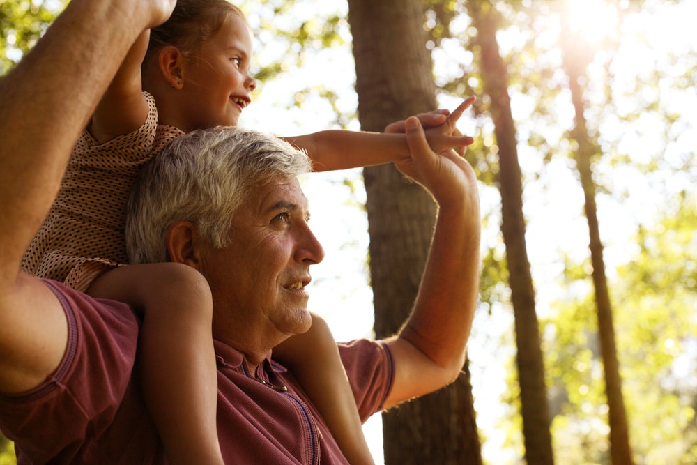 A Grandfather Carrying His Grandson On His Shoulders