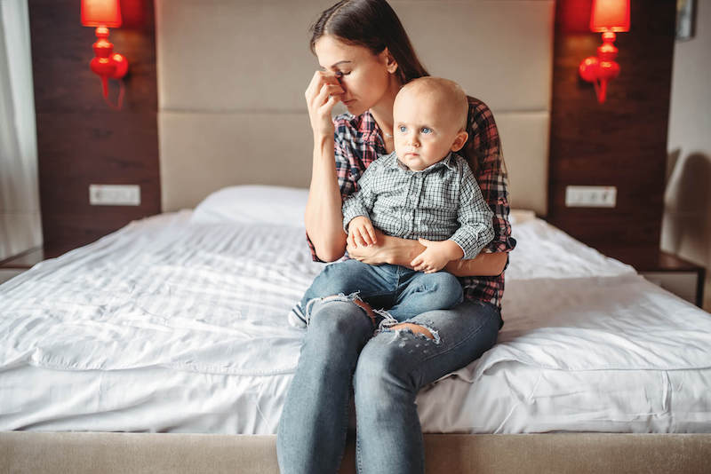 Mother And Child Upset Mother Holding A Toddler On Her Lap
