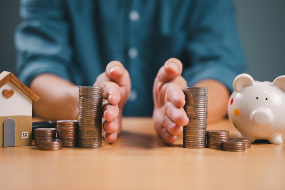 Divorce law and inheritance separation concept. Hand separate saving money, finance, home loan, debt return with piggybank and wood house.