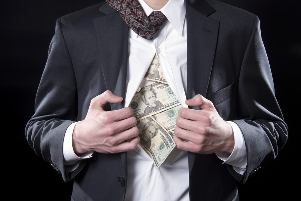 Photo for hidden money showing a a pulling back his shirt