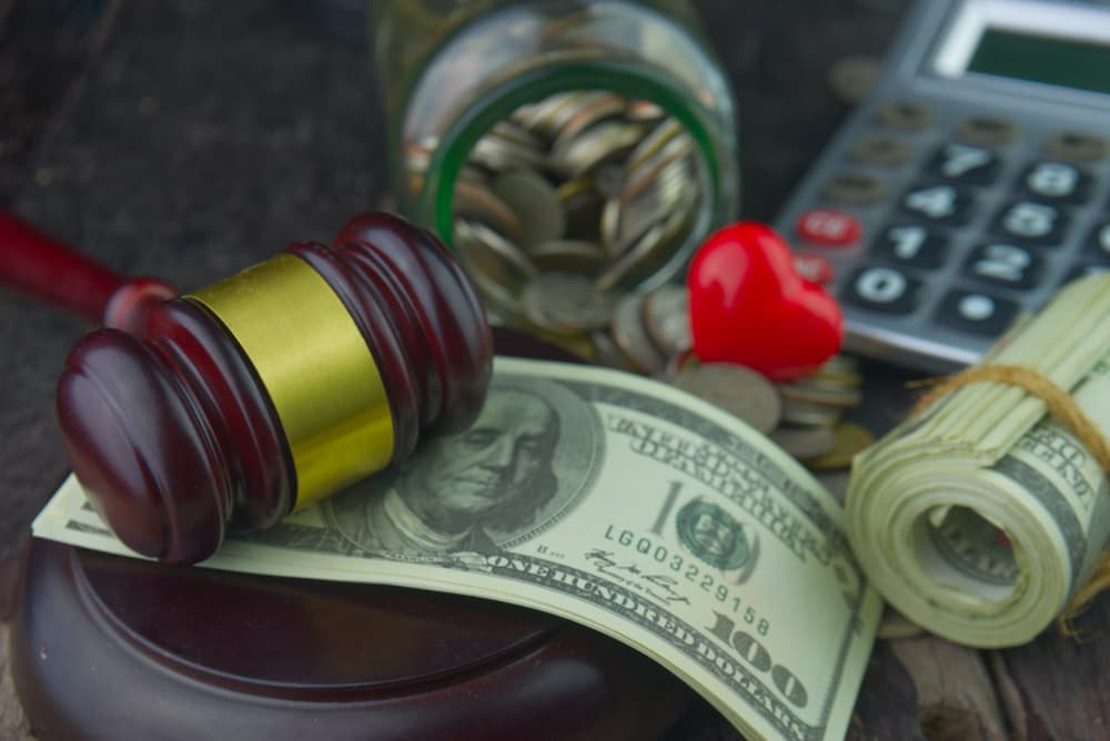 Judge wooden gavel with roll of dollar money banknote.