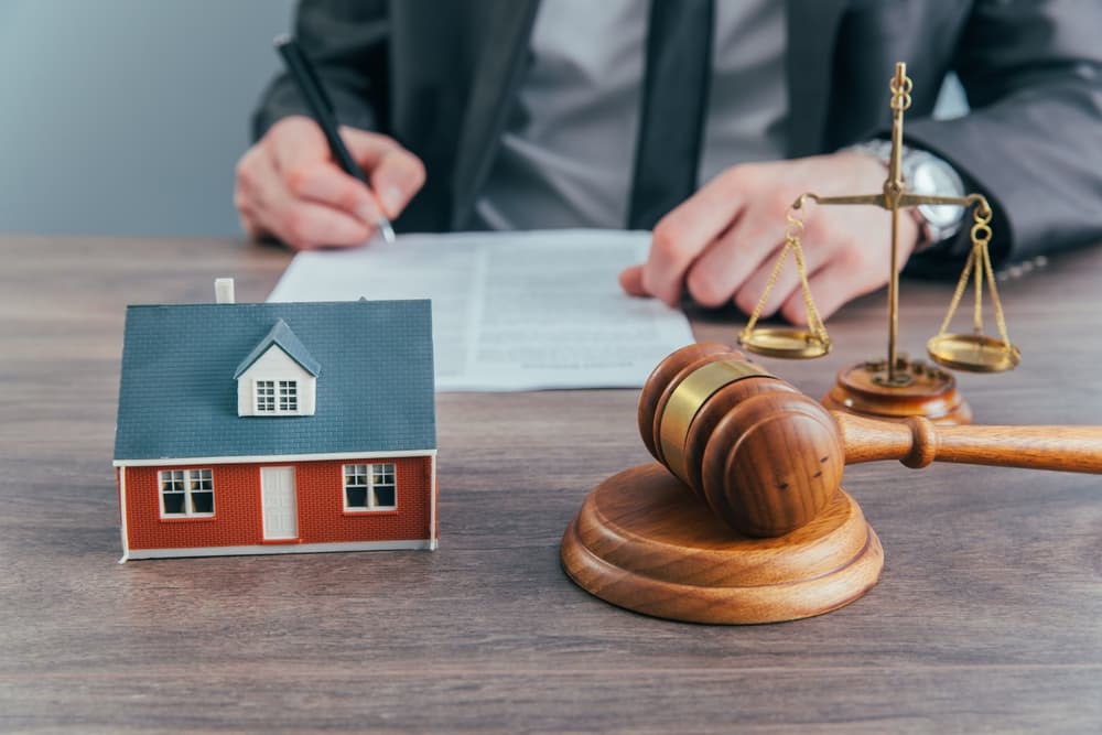 A lawyer working in his office and a house model lying on table